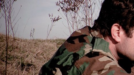 Soldat sitzt in der Natur